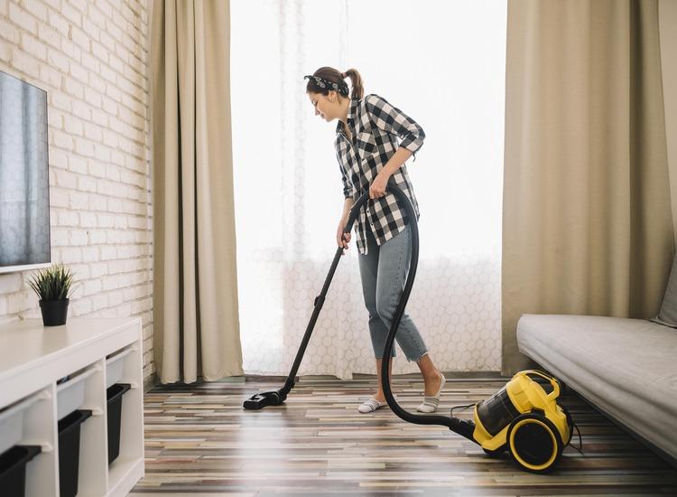 full-shot-woman-vacuuming-living-room